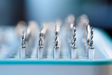 Diş implantlarının tamamı cerrahi tepside matkap uçları, profesyonel dişçilik ekipmanlarına yakın çekim..