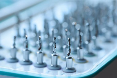 Diş implantlarının tamamı cerrahi tepside matkap uçları, profesyonel dişçilik ekipmanlarına yakın çekim..