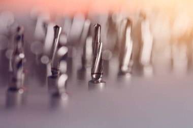 Diş implantı, cerrahi tepside matkap uçları, profesyonel dişçilik ekipmanlarına yakın çekim. Seçici odak.