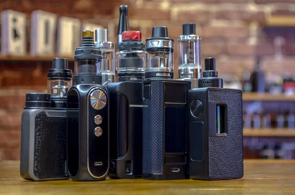 Yelek dükkanının arka planında elektronik sigara. Vaping için e-sigara. Popüler Vape aygıtları