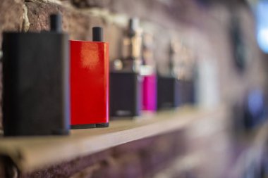 Yelek dükkanının arka planında elektronik sigara. Vaping için e-sigara. Popüler Vape aygıtları