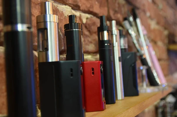 Yelek dükkanının arka planında elektronik sigara. Vaping için e-sigara. Popüler Vape aygıtları
