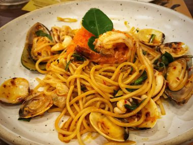 Baharatlı deniz mahsulleri spagetti restoranda beyaz plaka üzerinde