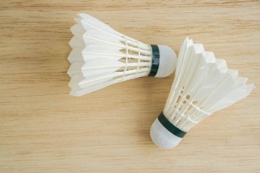 badminton oynamak için ahşap arka plan üzerinde beyaz Servisi horoz