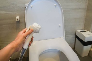 kadın tutun durulama sprey hortumu tuvalet temizliği için yukarıya kapatmak