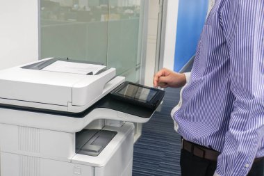Yukarıya adam çalışan iş inceden inceye gözden geçirmek ve ofiste iş belgeleri kopyalamak için çok işlevli yazıcı ile kapatmak