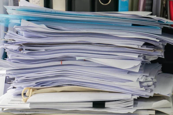 close up messy business documents piles on office desk