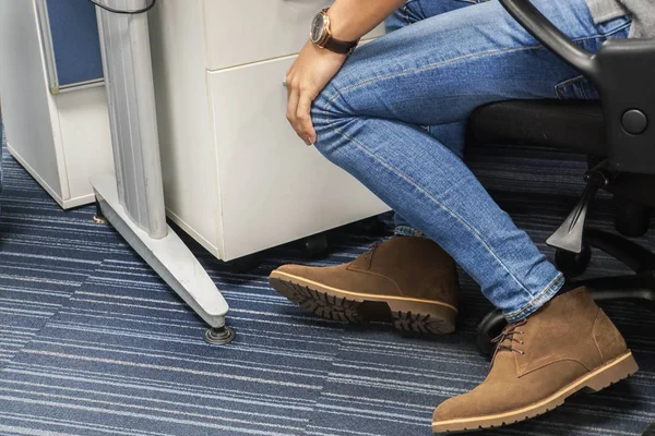 Stäng Upp Mannen Klädd Jeans Och Boot Skor Sit Kontorsstol — Stockfoto