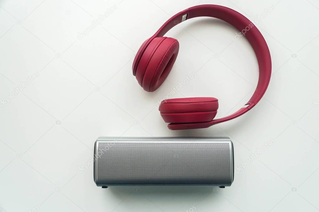 flat lay isolated wireless portable speaker with pink bluetooth headphones for music listening