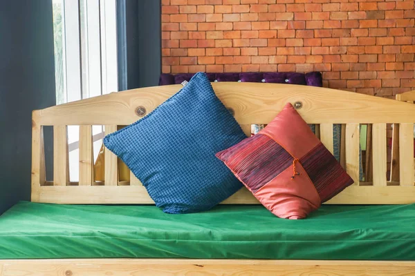 close up indoors wooden bench with fabric cushions for rest
