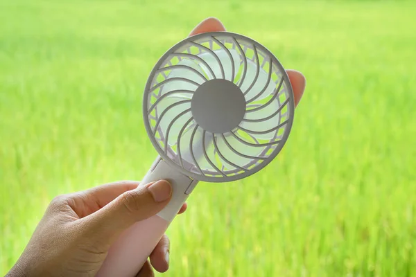 close up woman hold portable motor USB fan for outdoors travel