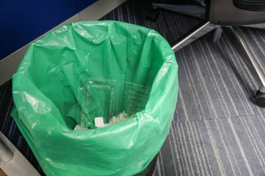 ofis masasında yeşil çanta ile çöp kutusu kadar yakın