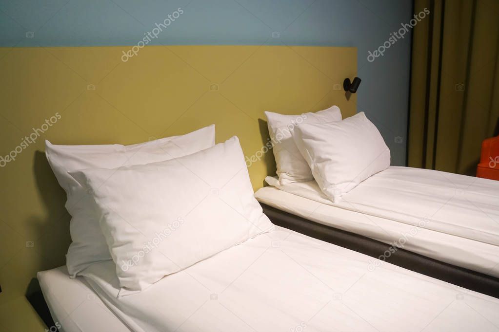 white mattress and comfortable pillows in hotel twin bedroom