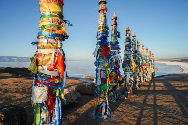 Irkutsk/Rusya-Şubat 14 2019: gün batımı zamanında Baykal Gölü 'nde Shaman Kayası 'nda kutsal kutupları yakın