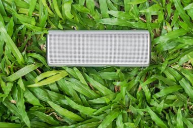 yaz aylarında müzik dinlemek için yeşil çim taşınabilir bluetooth hoparlör