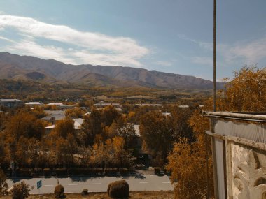 Sonbahar şehrinin penceresinden dağın arka planına bak