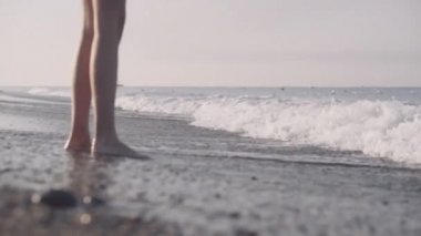 kız çıplak ayakla deniz kıyısı yürür