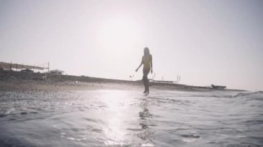 kız çıplak ayakla deniz kıyısı yürür