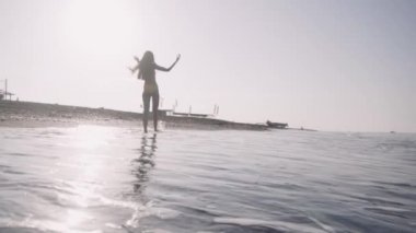 kız çıplak ayakla deniz kıyısı yürür