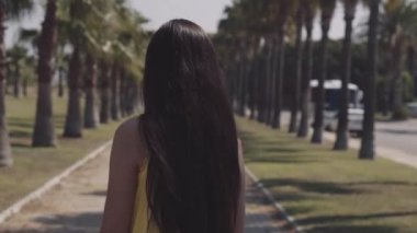 güzel kız bir palmiye ağacı gezer