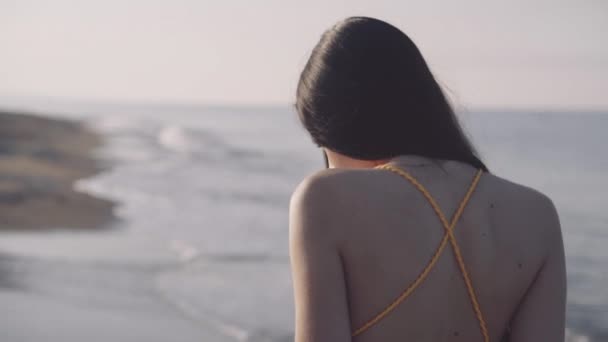 Das Mädchen geht barfuß am Meeresufer entlang — Stockvideo