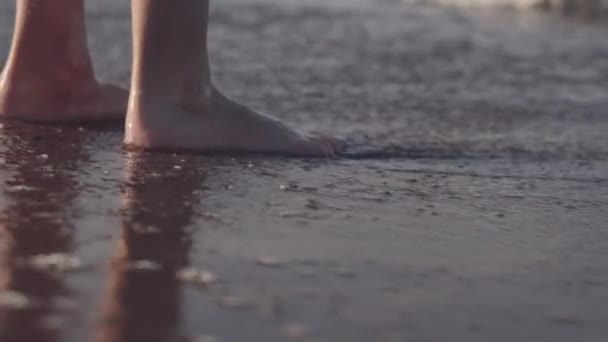 Девочка идет бароногой вдоль берега моря — стоковое видео