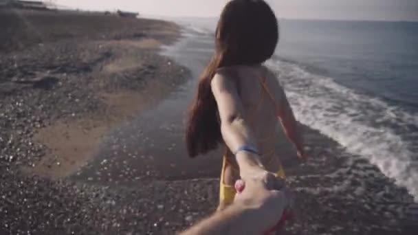 女の子を裸足で海岸に沿って歩く — ストック動画