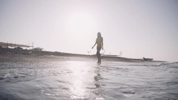 Dívka chodí naboso podél pobřeží — Stock video