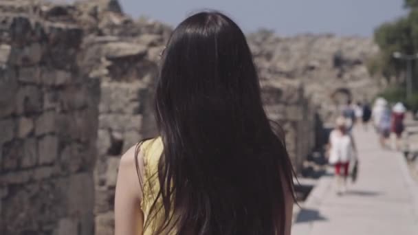 Egy lány séták egy ősi város romjai között — Stock videók
