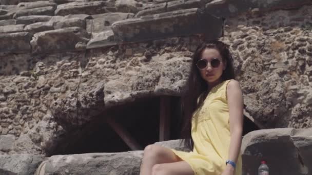 La chica se sienta en el requisito del antiguo teatro romano — Vídeos de Stock