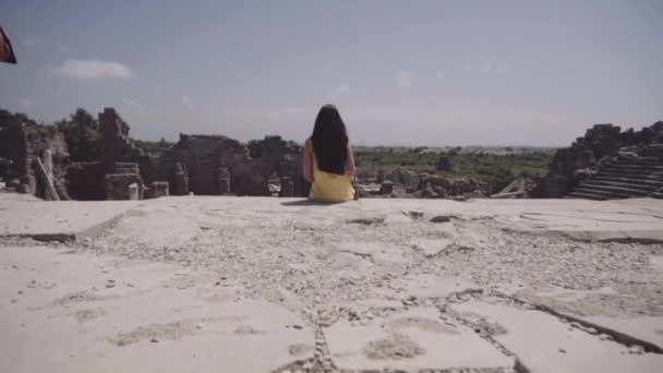Το κορίτσι που κάθεται στον τα απαιτούμενα από το αρχαίο Ρωμαϊκό Θέατρο — Αρχείο Βίντεο
