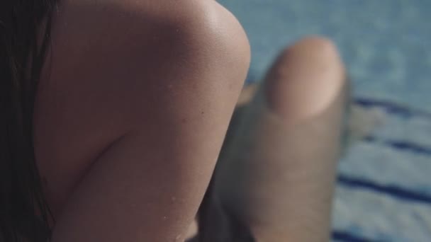 Mooi meisje ligt in het zwembad en sunbathes — Stockvideo