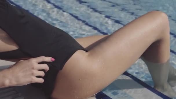 Beautiful girl lies in the pool and sunbathes — Stock Video