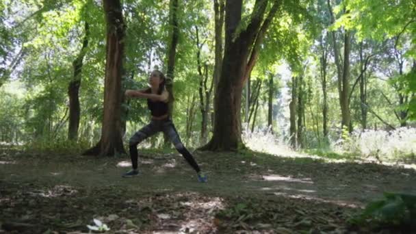 The girl is engaged in fitness in the forest. Sport in the forest. — Stock Video