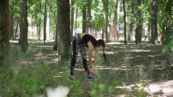 The girl is engaged in fitness in the forest. Sport in the forest. — Stock Video