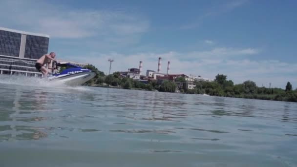 Un giovane ragazzo sta cavalcando un idrociclo sul lago — Video Stock