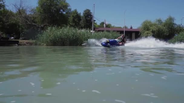 Un giovane ragazzo sta cavalcando un idrociclo sul lago — Video Stock