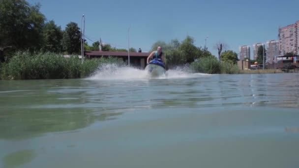Молодой парень катается на гидроцикле по озеру — стоковое видео