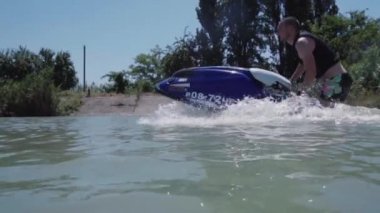 Genç bir adam bir hydrocycle gölde biniyor