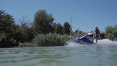 Genç bir adam bir hydrocycle gölde biniyor