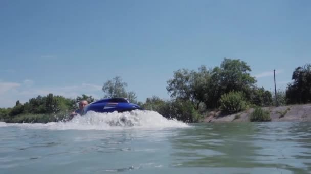 Un giovane ragazzo sta cavalcando un idrociclo sul lago — Video Stock