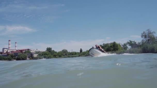 Um jovem está montando um hidrociclo no lago — Vídeo de Stock