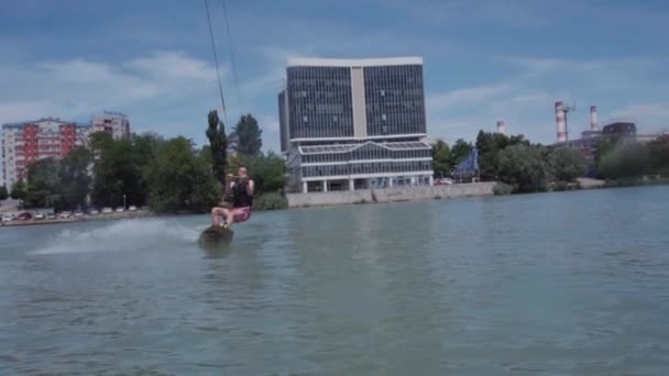 Un chico joven está montando un hidrociclo en el lago — Vídeo de stock