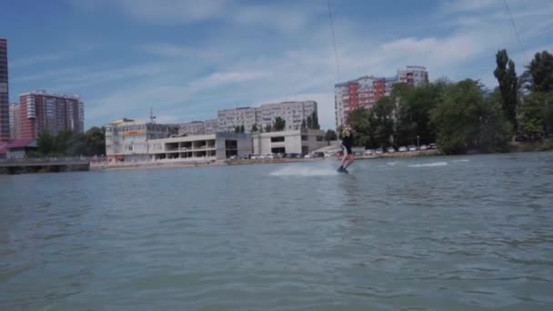 Un chico joven está montando un hidrociclo en el lago — Vídeo de stock