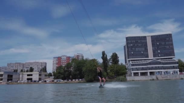 Un chico joven está montando un hidrociclo en el lago — Vídeo de stock