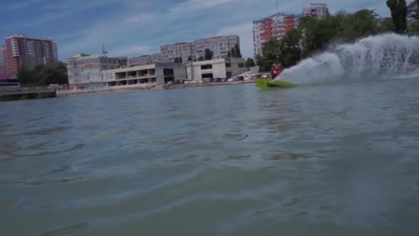Un chico joven está montando un hidrociclo en el lago — Vídeo de stock