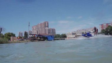 Genç bir adam bir hydrocycle gölde biniyor