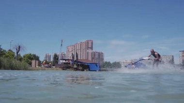 Genç bir adam bir hydrocycle gölde biniyor