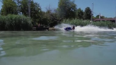 Genç bir adam bir hydrocycle gölde biniyor