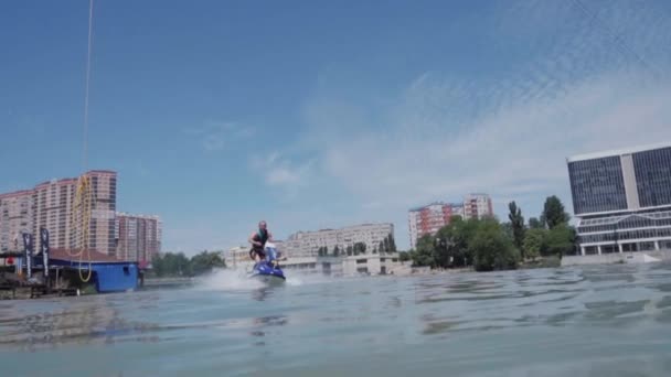 Un chico joven está montando un hidrociclo en el lago — Vídeo de stock